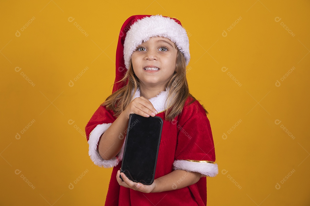 Linda menina criança segurando celular usando chapéu papai Noel feliz natal
