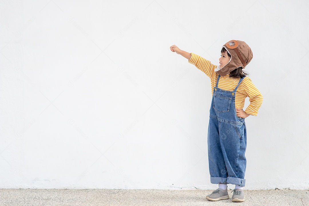 Uma garotinha fantasiada de astronauta está brincando e sonhando.