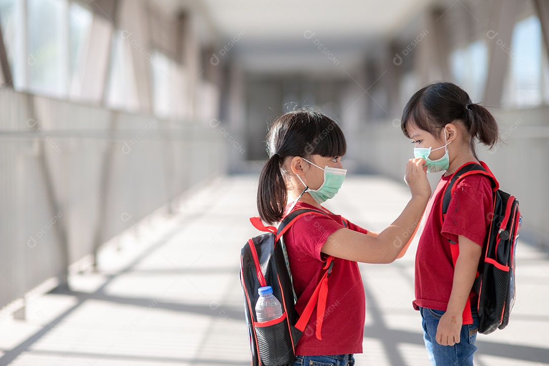 Menina e irmã usando máscara facial indo para a escola.