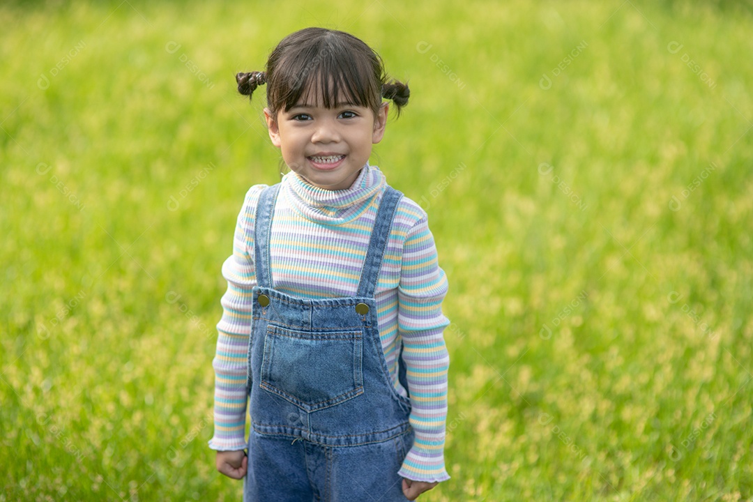 Retrato de uma menina bonita e feliz sorrindo ao ar livre aproveitando.