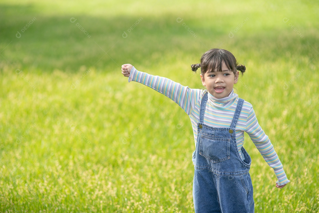 Retrato de uma menina bonita e feliz sorrindo ao ar livre aproveitando.