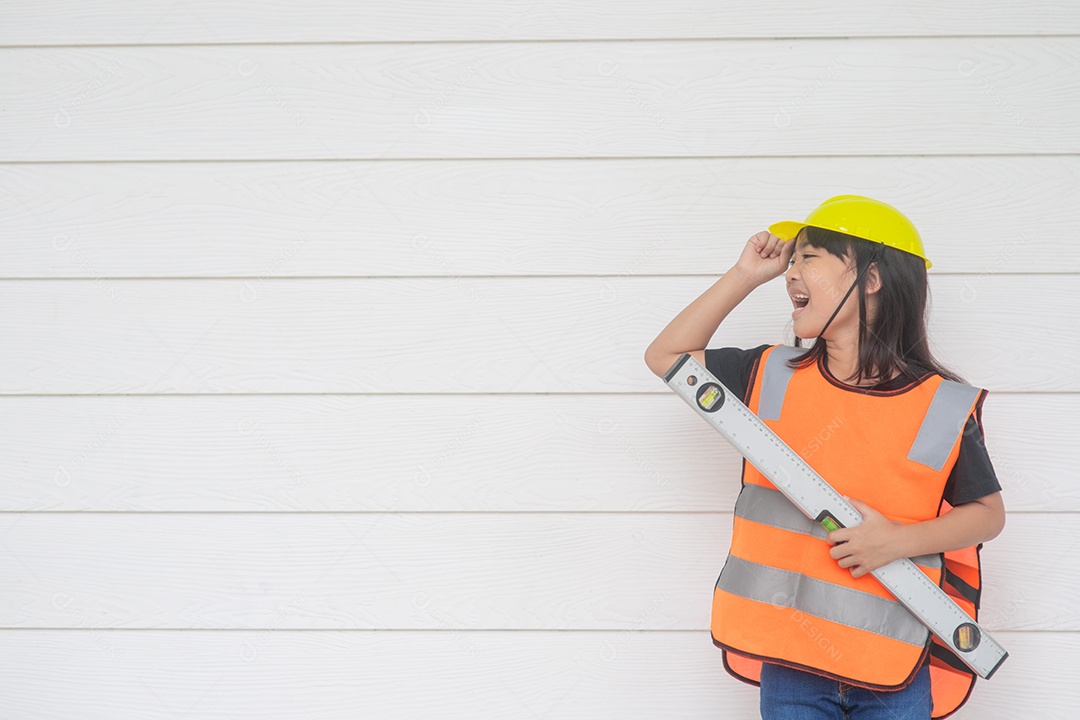 Garota asiática vestindo camisas reflexivas e um capacete amarelo