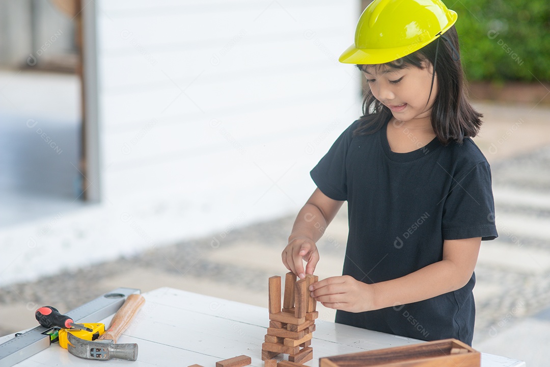 Menina asiática brincando como capacete de engenheiro estão sorrindo