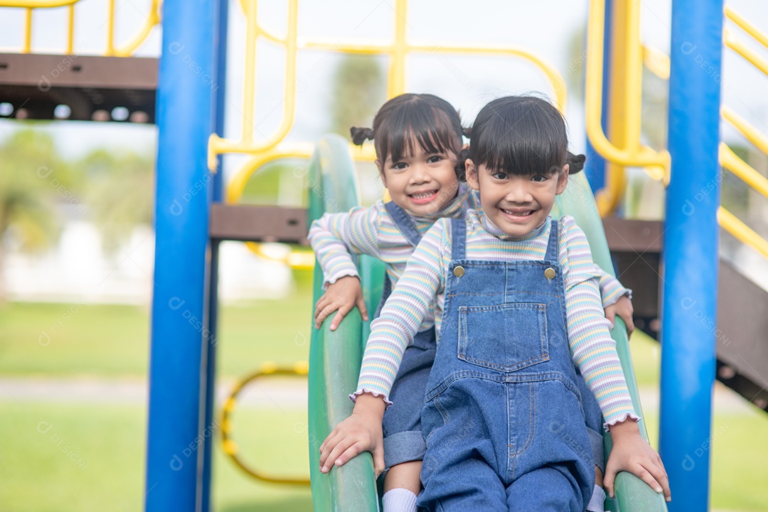 Meninas asiáticas irmãs felizes se divertindo no parque