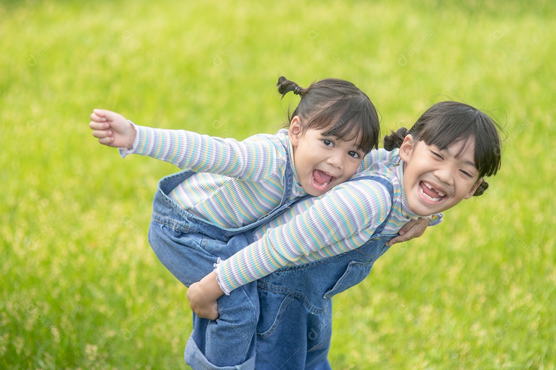 Meninas asiáticas irmãs felizes se divertindo no parque