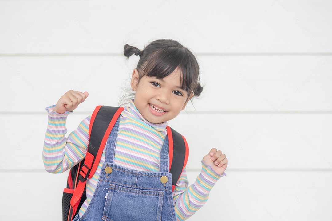 De volta à escola menina asiática fofa com mochila segurando livros