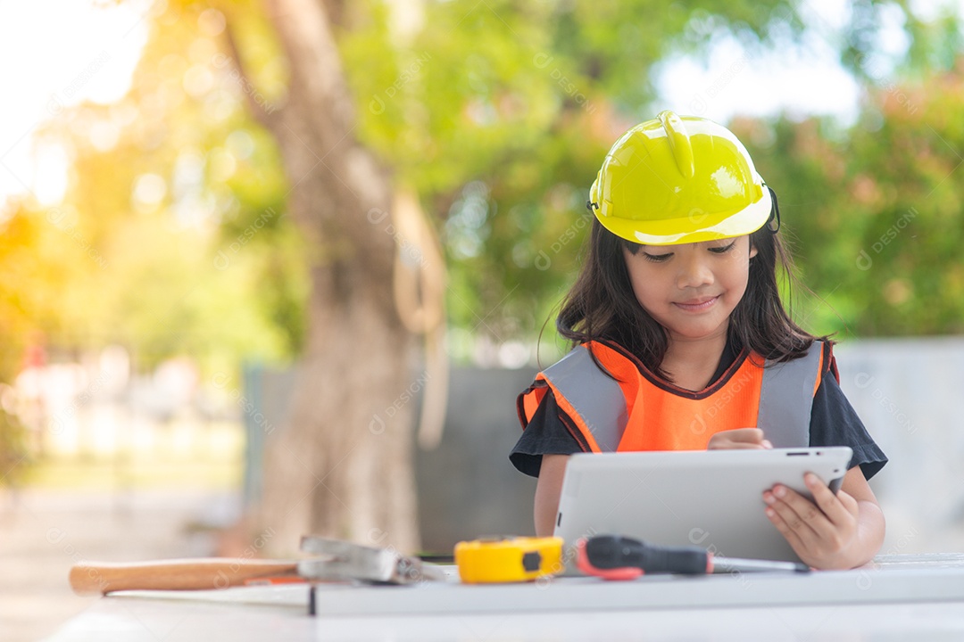 Garota asiática vestindo camisas reflexivas e um capacete amarelo