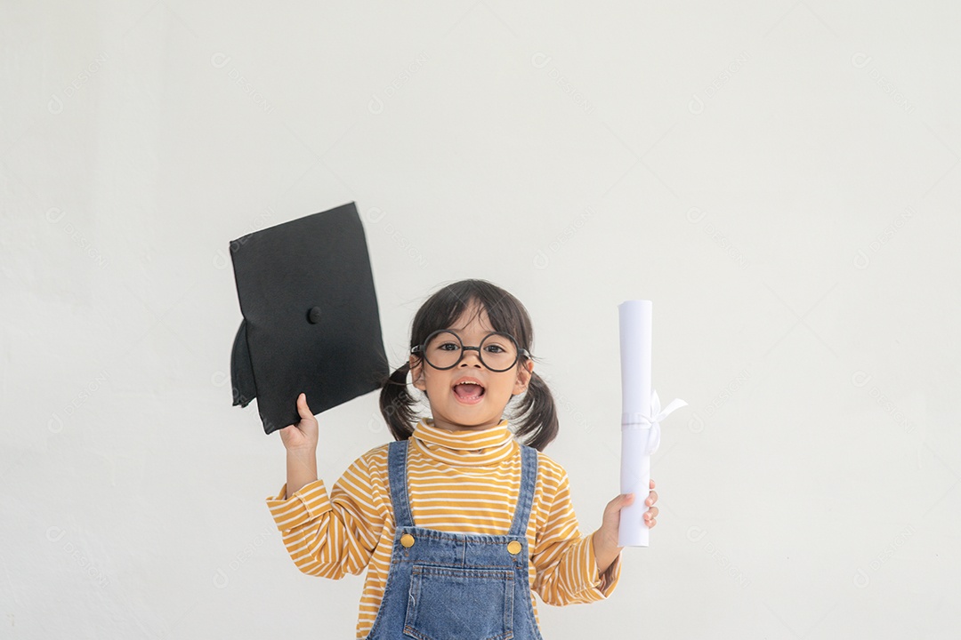Menina asiática vestindo um boné de formatura e segurando o diploma em fundo branco