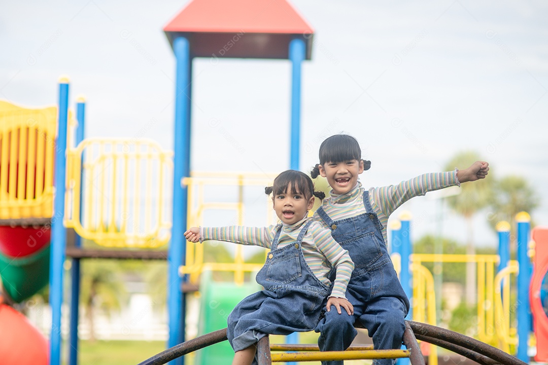 Irmãs de meninas bonitas se divertindo no playground ao ar livre