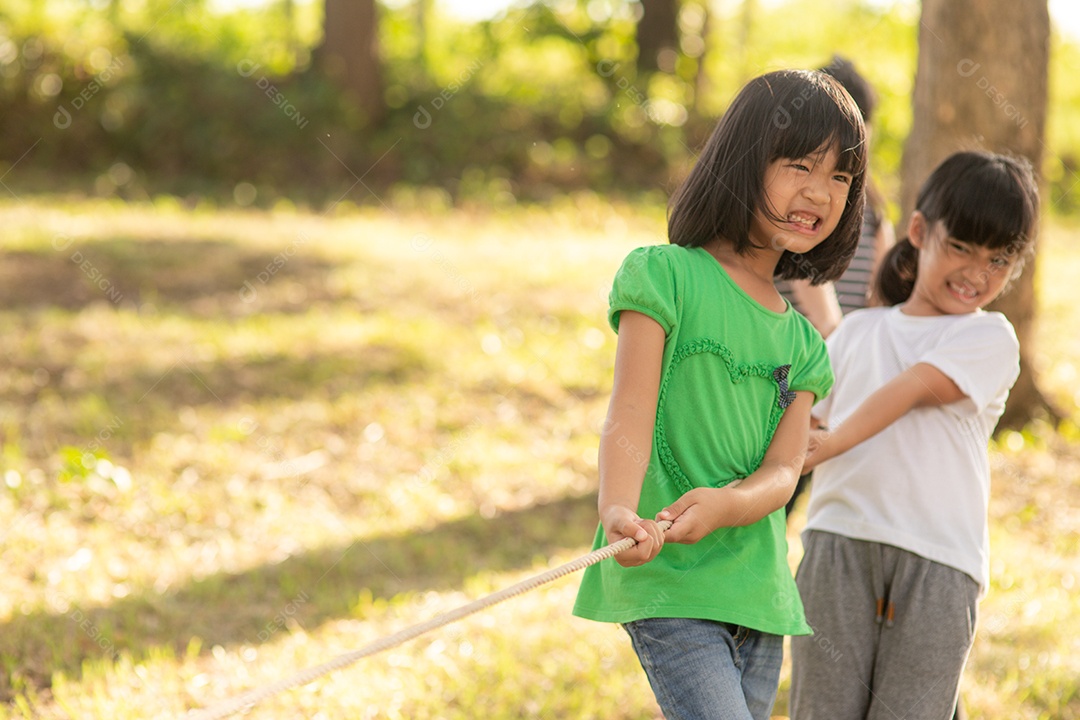 Crianças brincando de cabo de guerra sobre parque