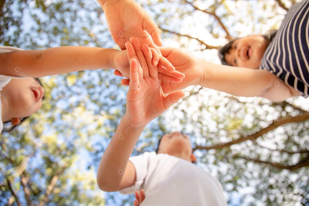 Conceito de unidade. Vista inferior de crianças juntando as mãos
