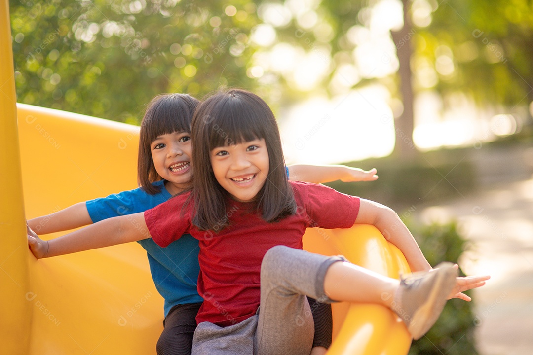 Irmãs de meninas bonitas se divertindo no playground ao ar livre