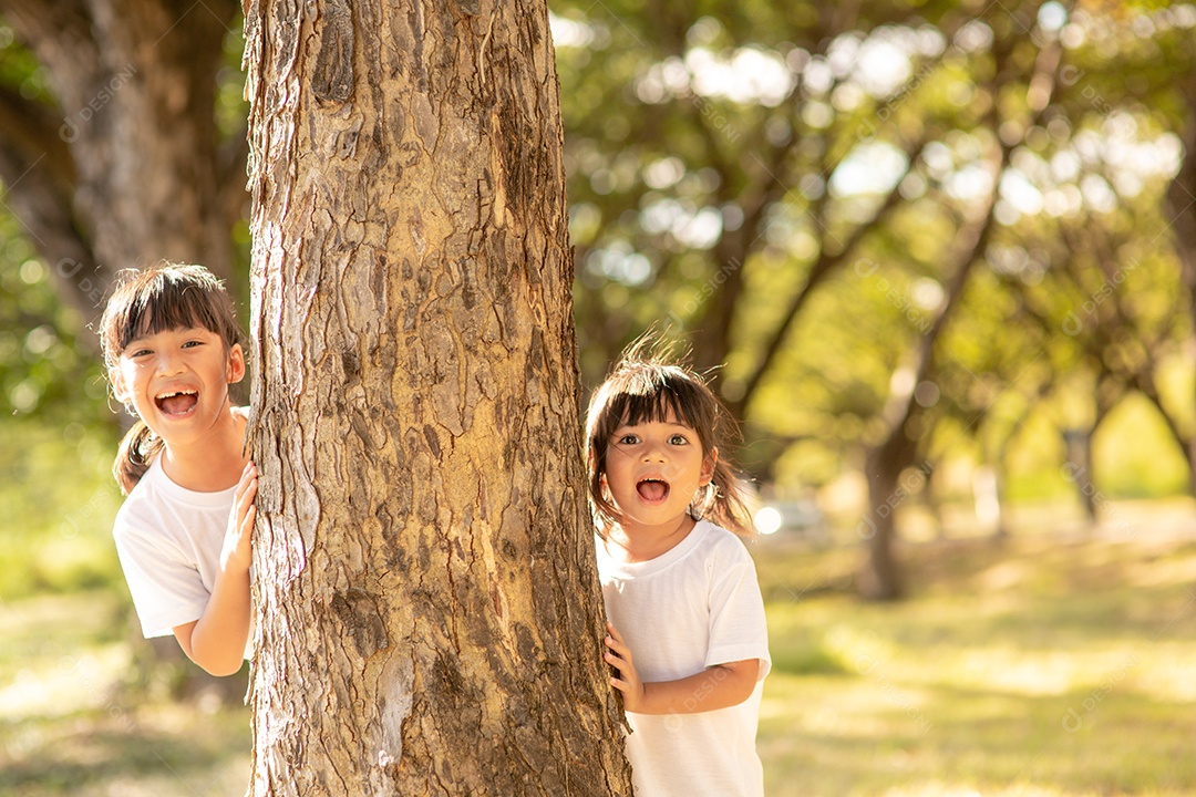 Meninas está brincando de esconde-esconde no parque