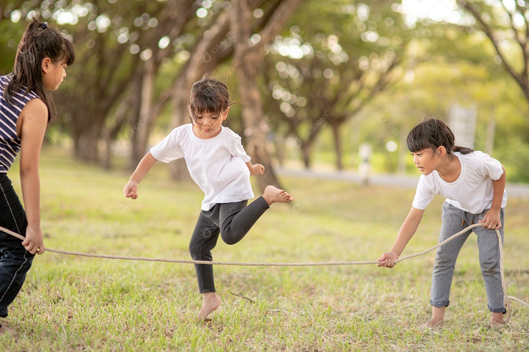 Crianças felizes brincando juntos com pular corda ao ar livre