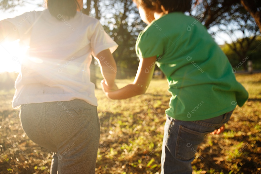 Two girls running on the lawn in the city park outdoors. freedom