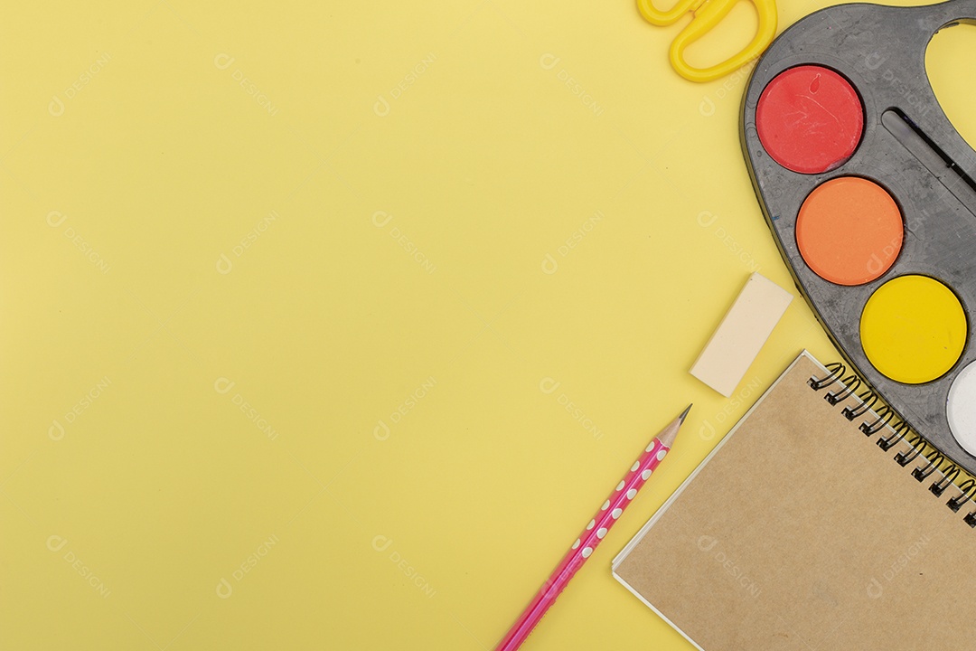 Diferentes artigos de papelaria em fundo amarelo