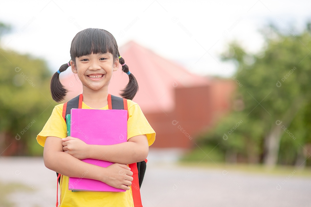 De volta à escola menina asiática fofa com mochila segurando livros