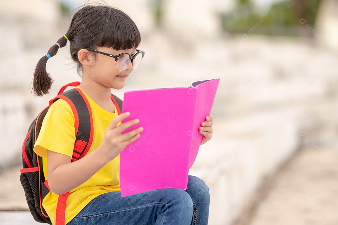 Linda menina jovem inteligente lendo livro criança estudante