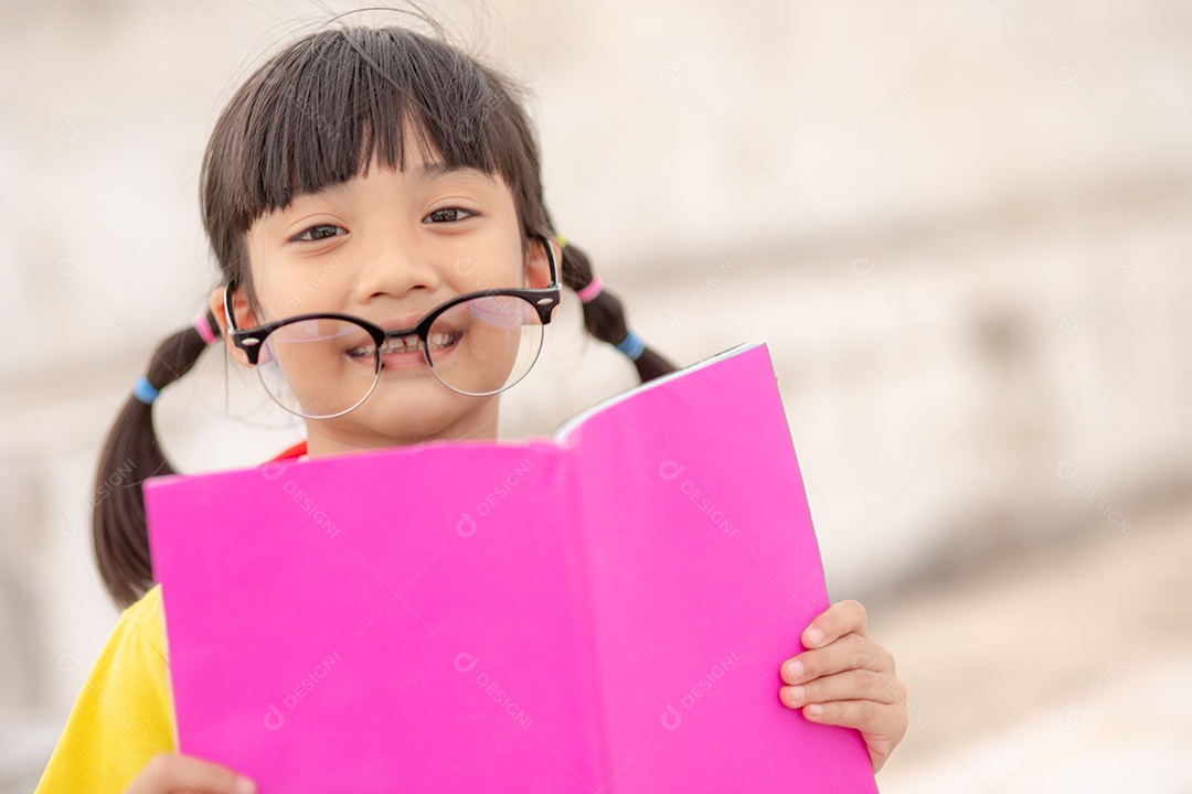 Linda menina jovem inteligente lendo livro criança estudante