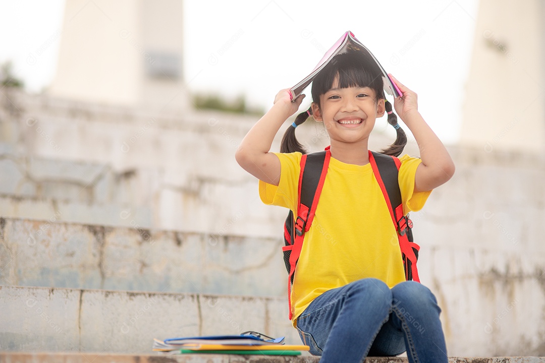 Linda menina jovem inteligente lendo livro criança estudante