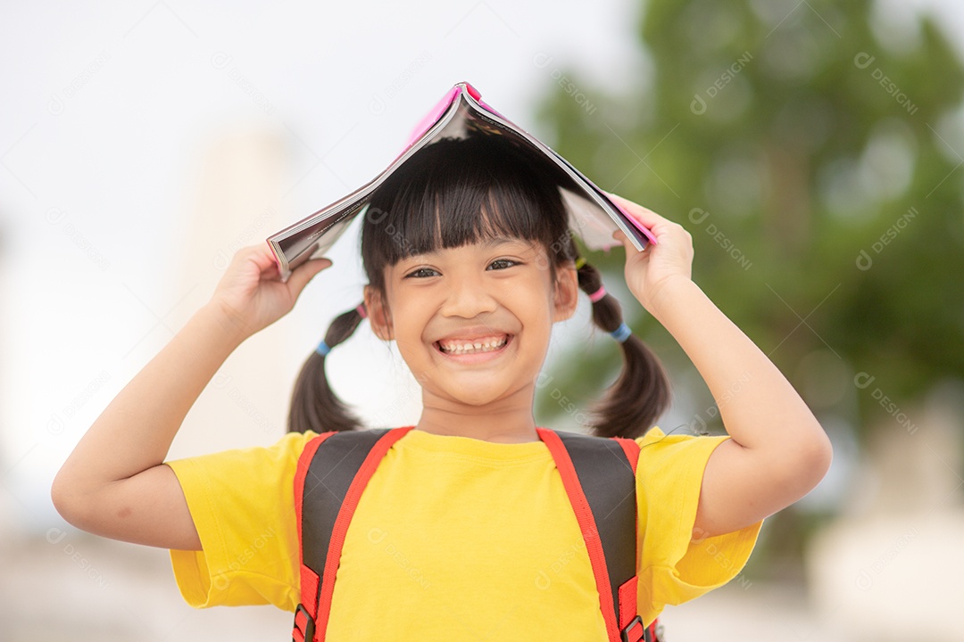 Menina bonita a menina está feliz com o livro
