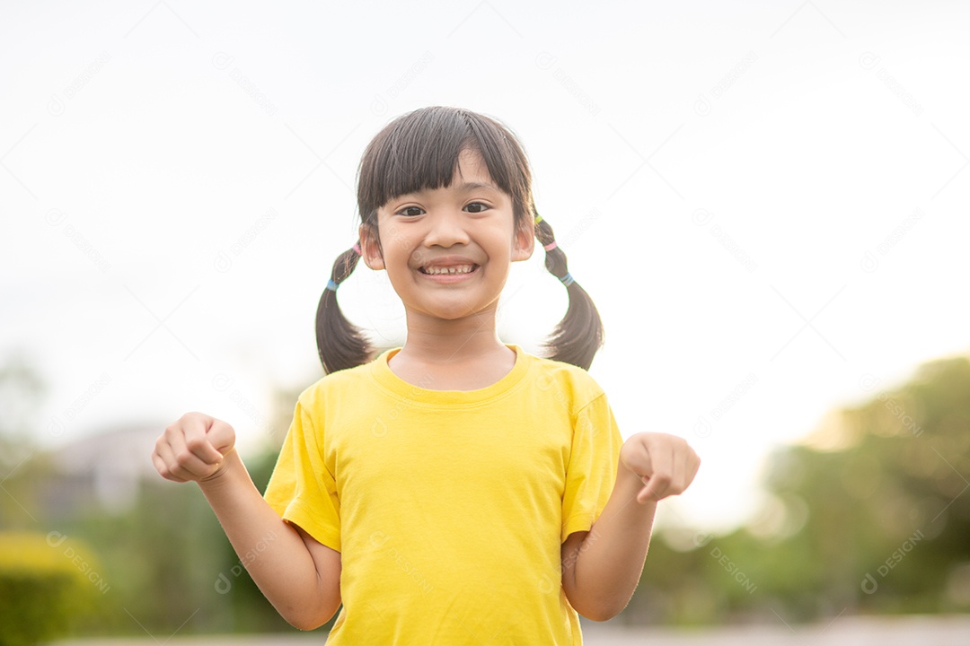 Menina asiática feliz mostrando os dentes da frente com um grande sorriso.