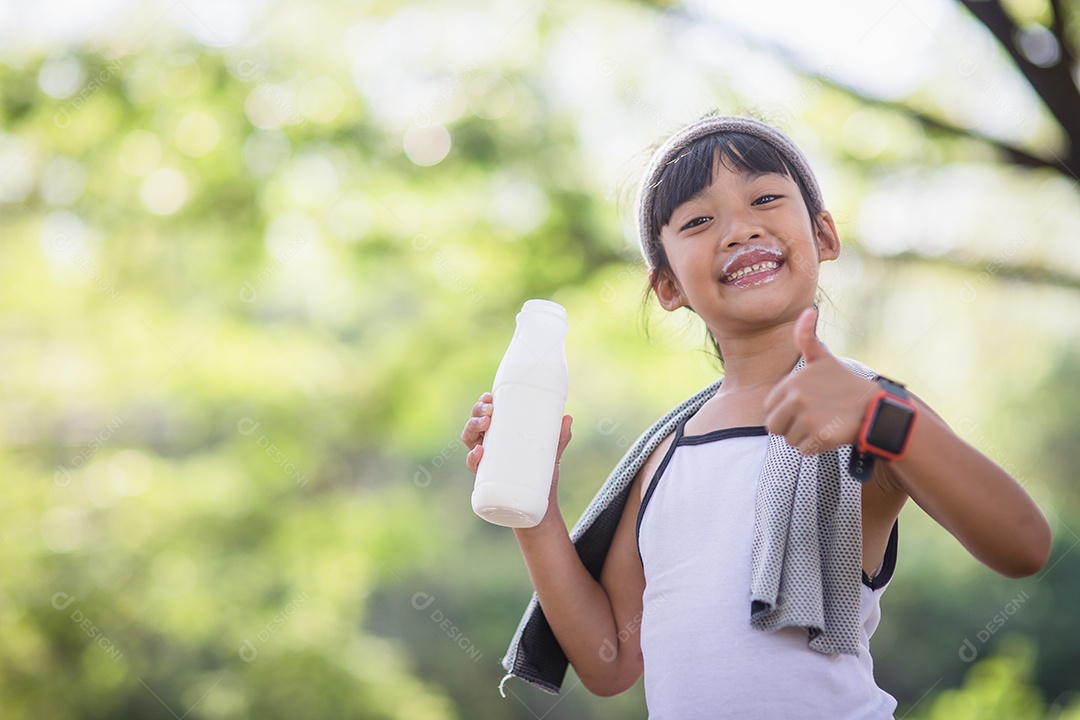 Linda garotinha asiática está bebendo leite