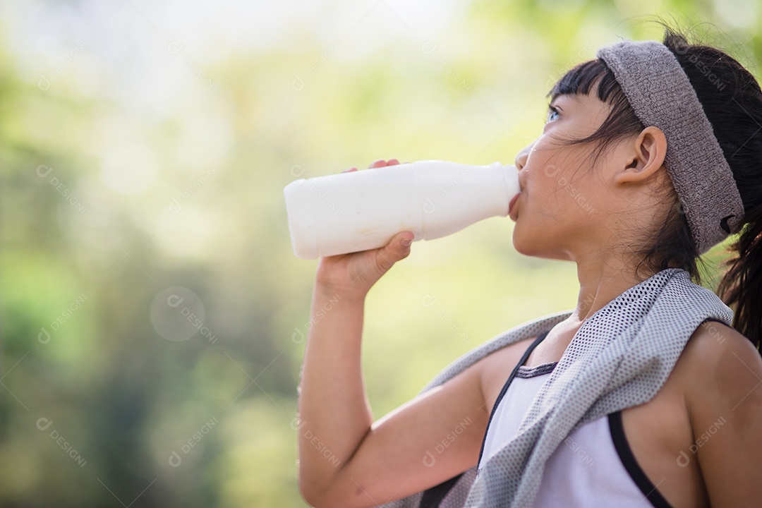 Linda garotinha asiática está bebendo leite