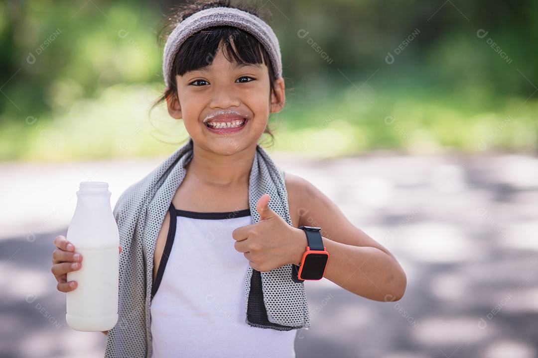 Linda garotinha asiática está bebendo leite