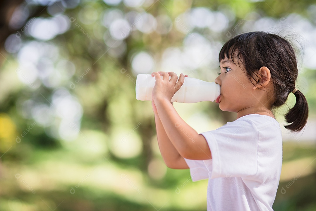 Linda garotinha asiática está bebendo leite