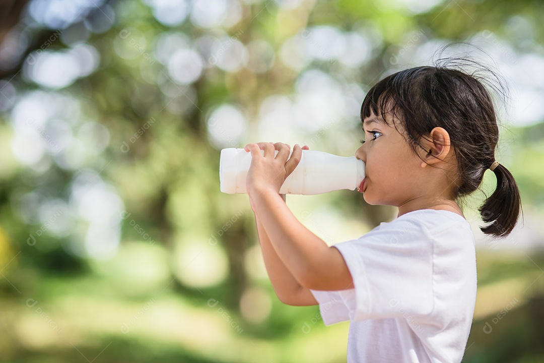 Linda garotinha asiática está bebendo leite