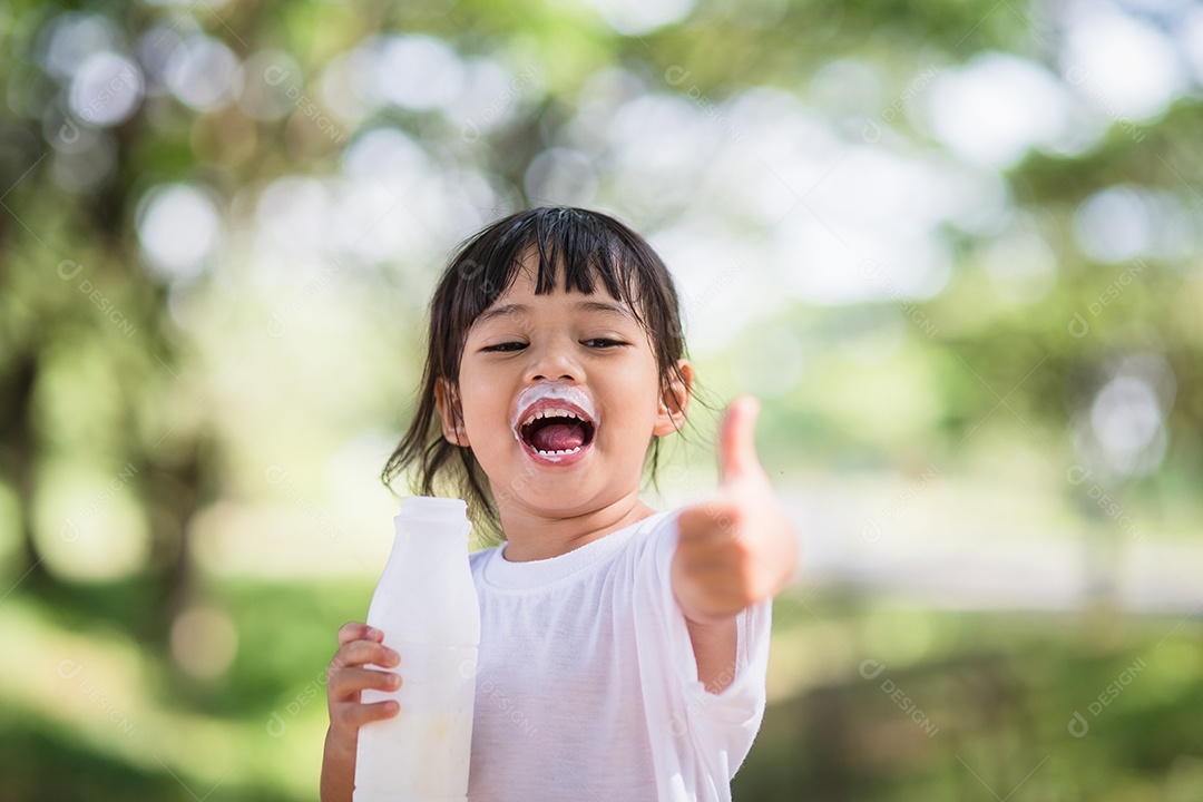 Linda garotinha asiática está bebendo leite