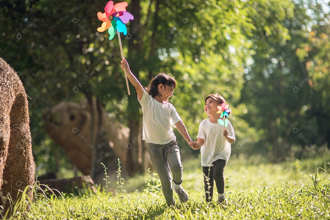Felizes meninas de crianças asiáticas com turbina eólica no jardim