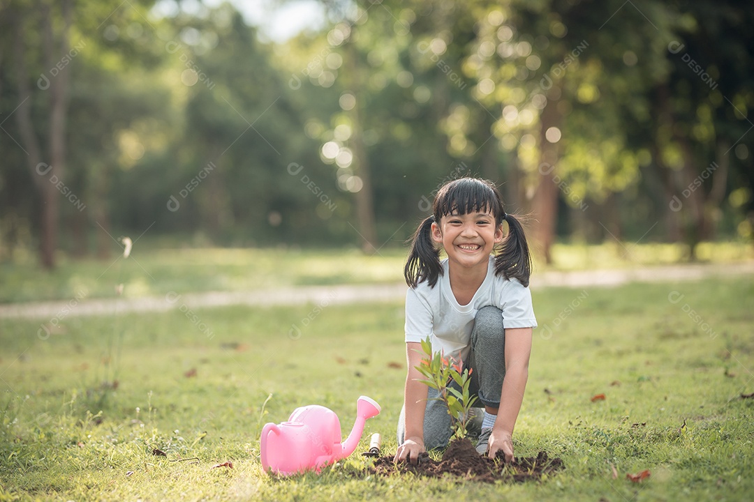 Menina asiática fechada plantando uma árvore na natureza verde
