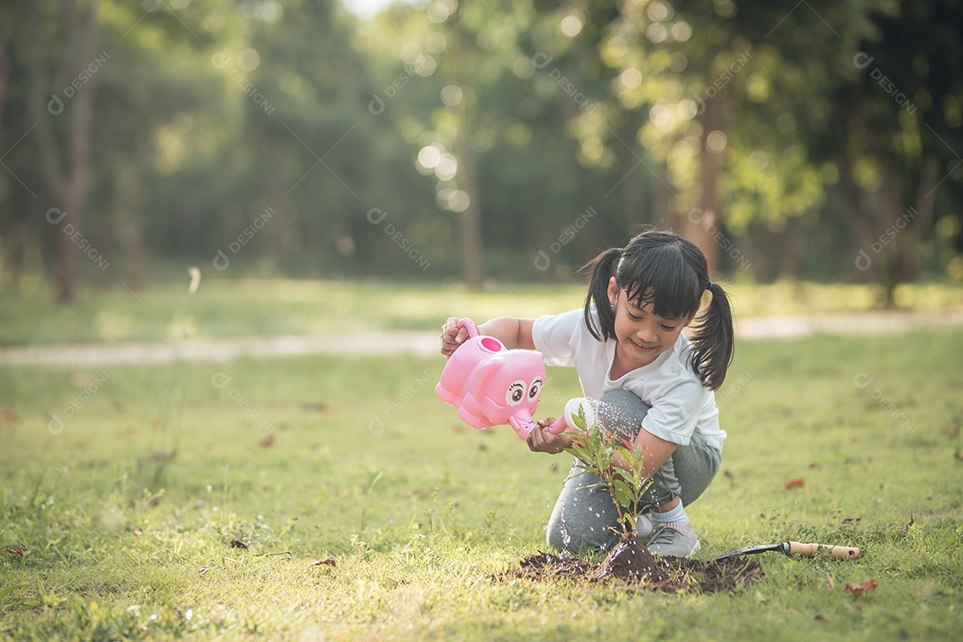 Menina asiática fechada plantando uma árvore na natureza verde