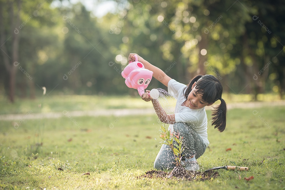 Menina asiática fechada plantando uma árvore na natureza verde