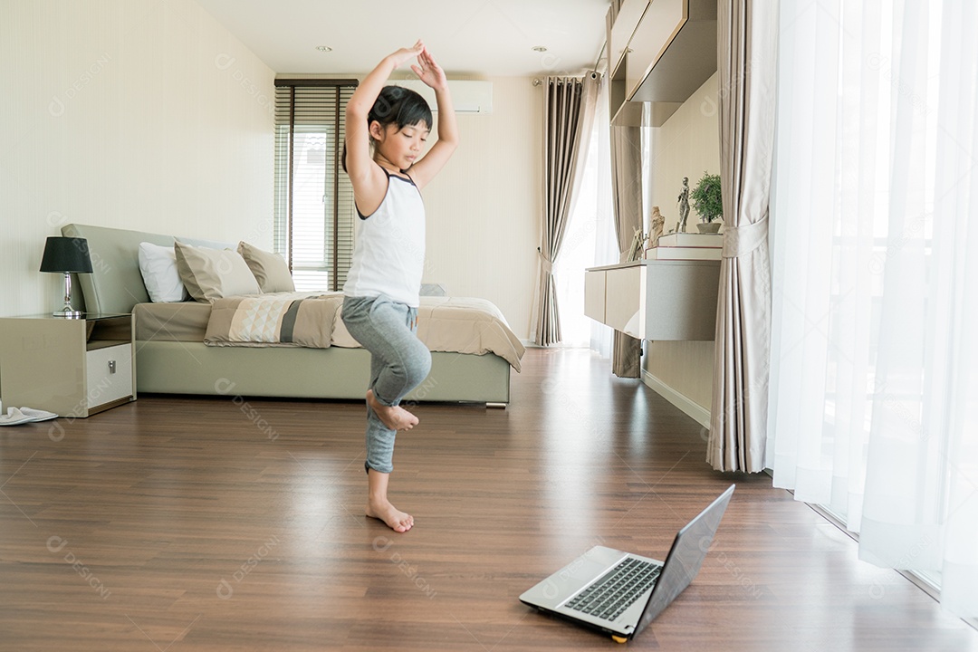 Menina bonitinha em roupas esportivas assistindo vídeo online no laptop