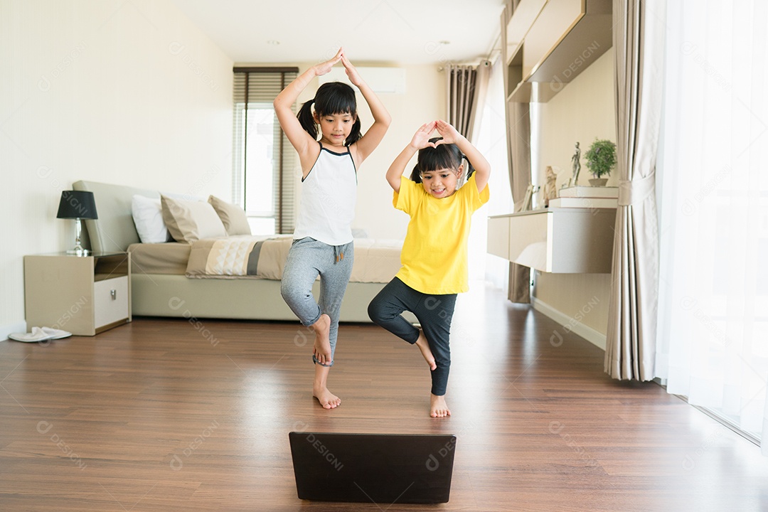 Duas meninas praticando ioga, alongamento, fitness por vídeo