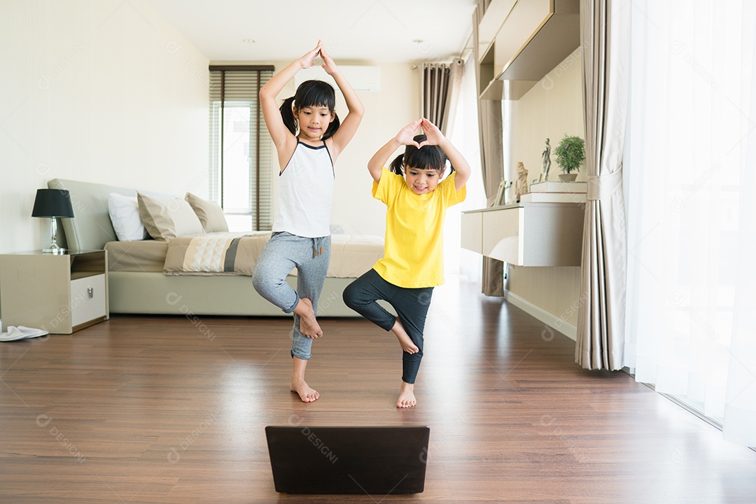 Duas meninas praticando ioga, alongamento, fitness por vídeo