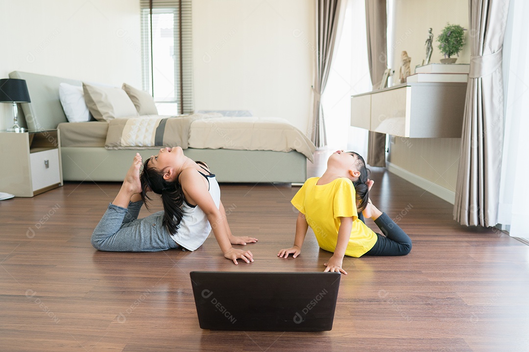 Duas meninas praticando ioga, alongamento, fitness por vídeo