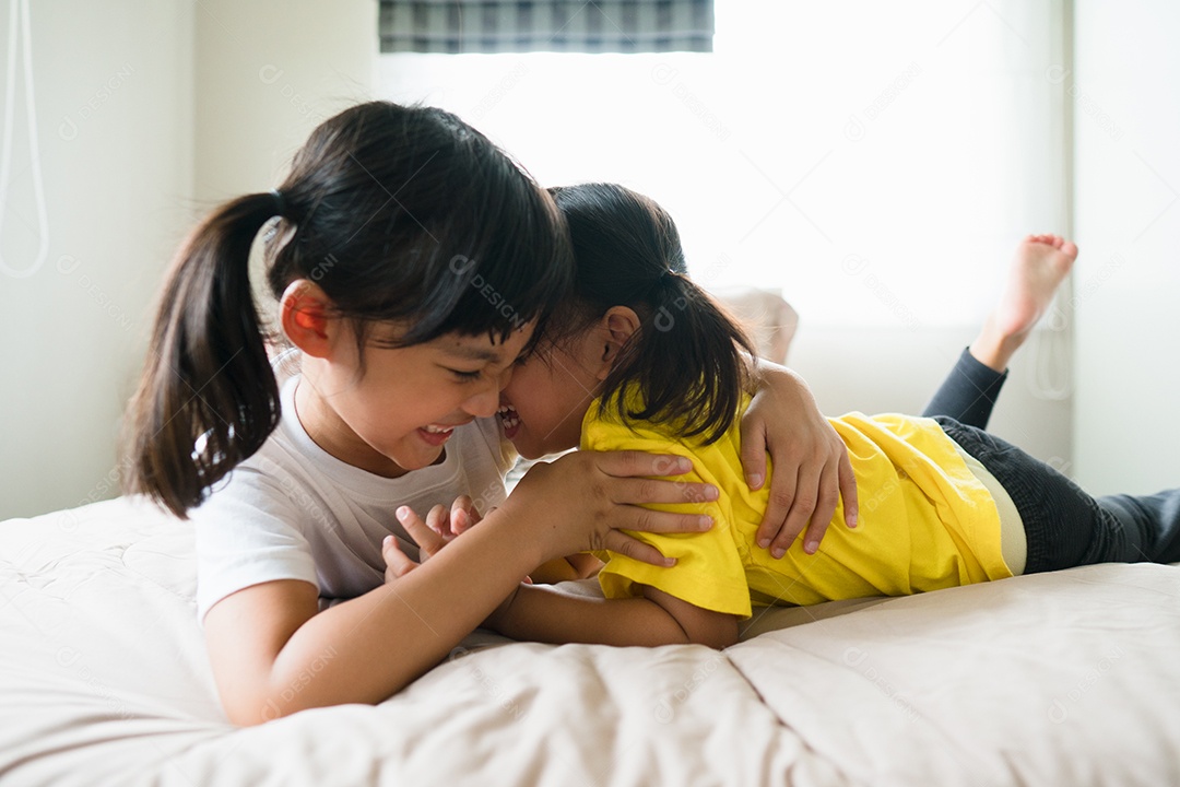 Lindas crianças asiáticas deitadas na cama