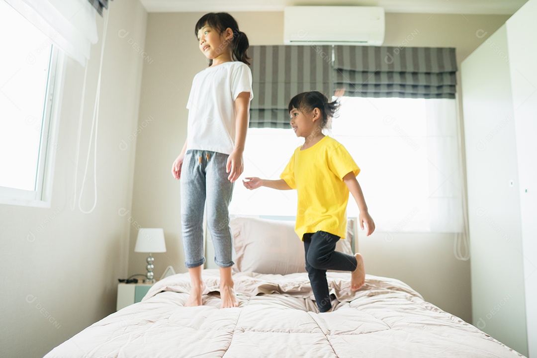 Duas meninas pulando na cama ao brincar juntos