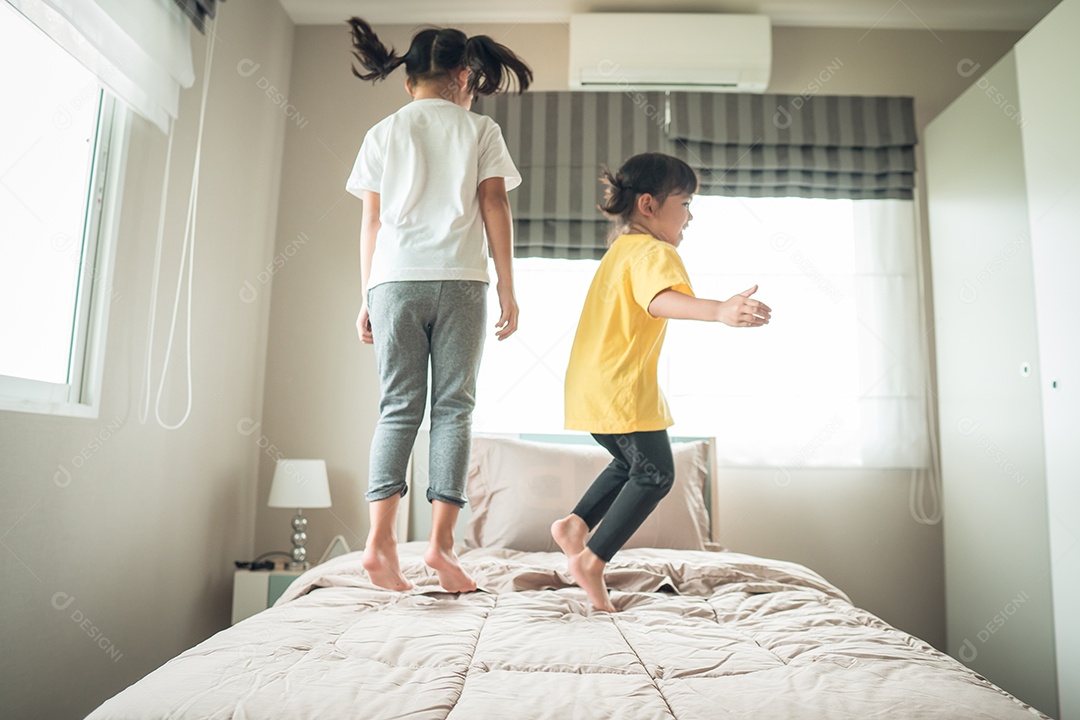 Duas meninas pulando na cama ao brincar juntos