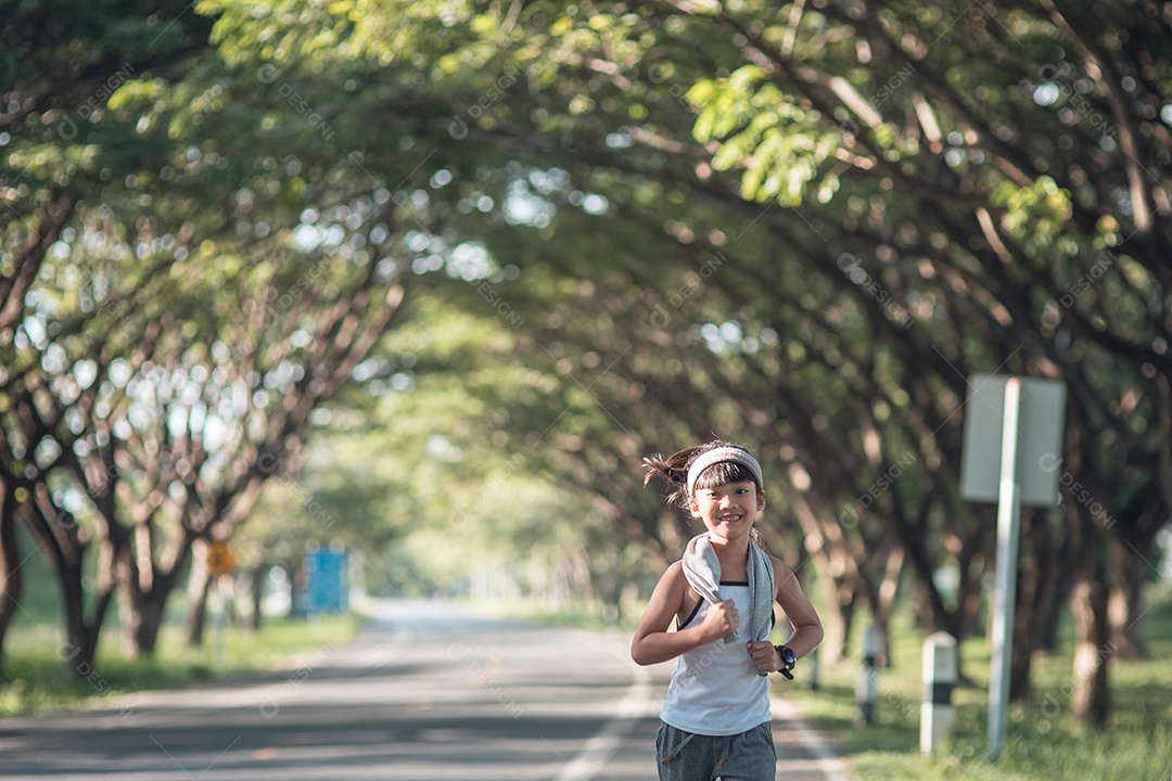 Menina criança feliz correndo no parque no verão na natureza.