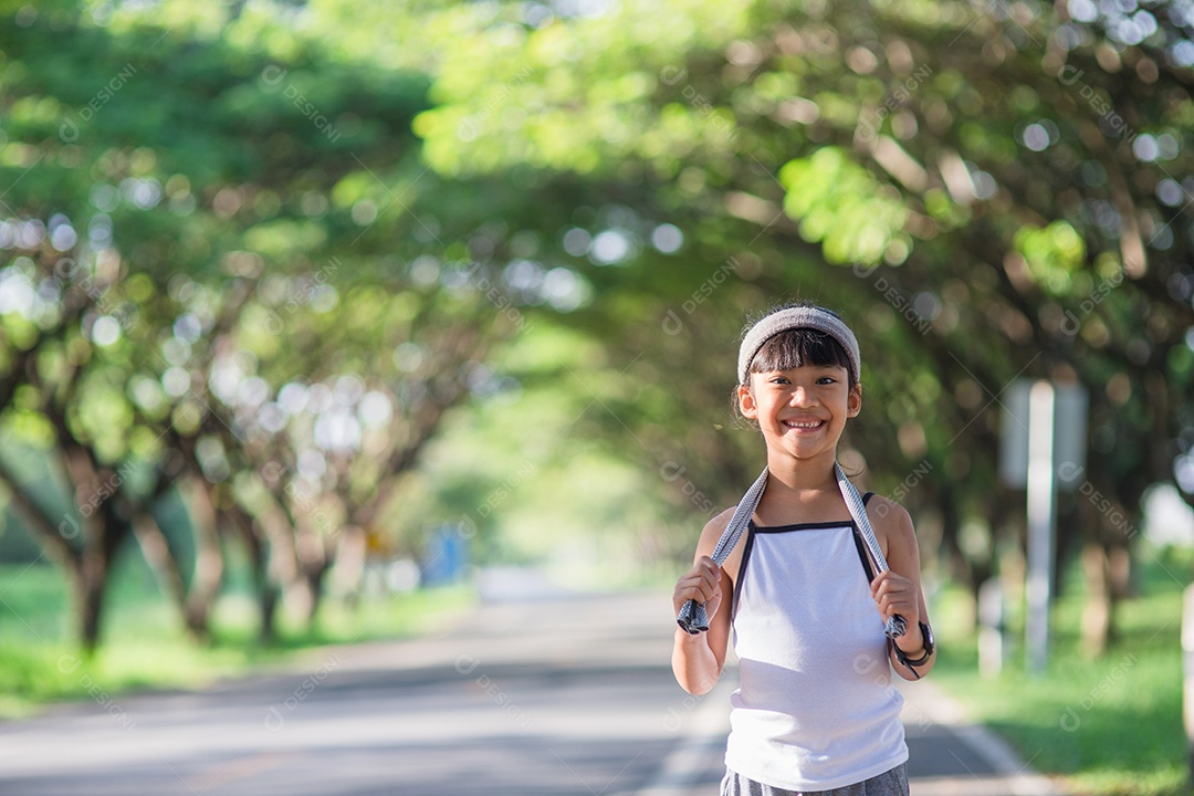 Menina criança feliz correndo no parque no verão na natureza.