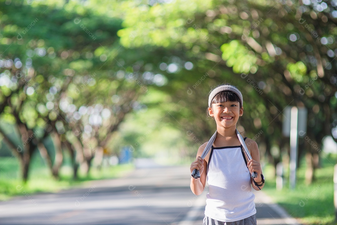Menina criança feliz correndo no parque no verão na natureza.