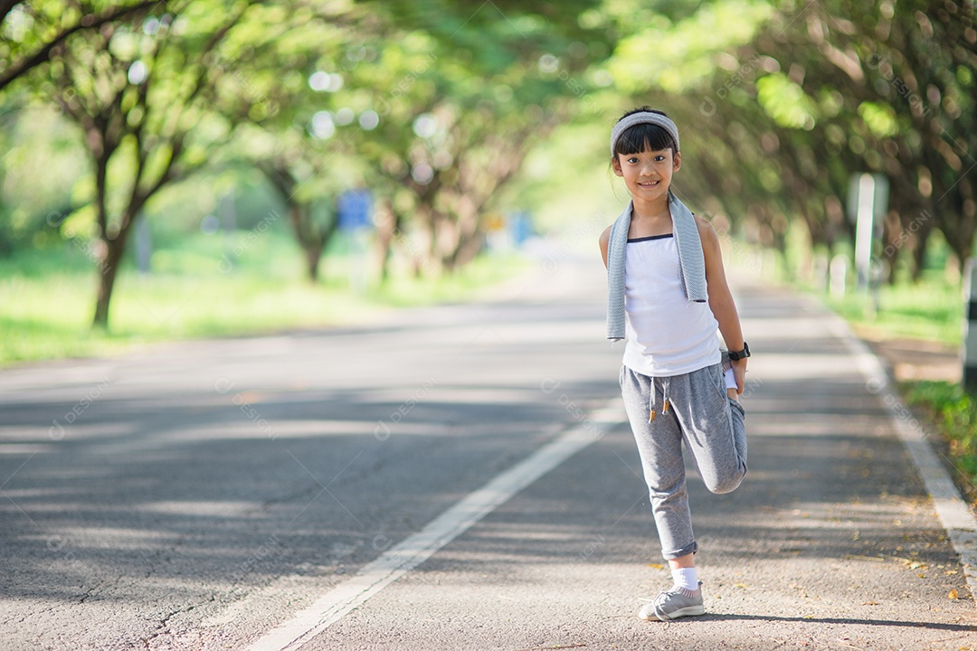 Exercício bonito da menina asiática no fundo do jardim.