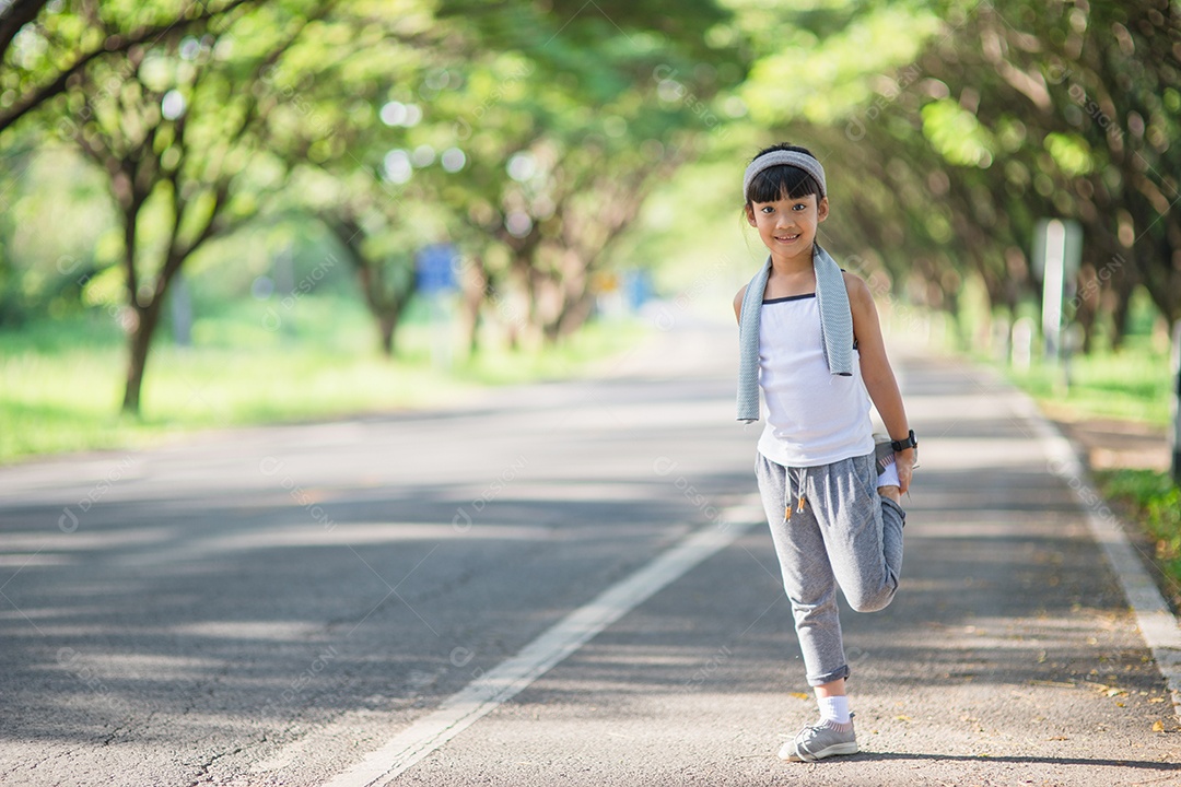 Exercício bonito da menina asiática no fundo do jardim.