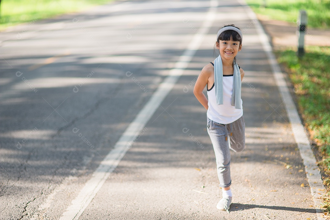 Exercício bonito da menina asiática no fundo do jardim.