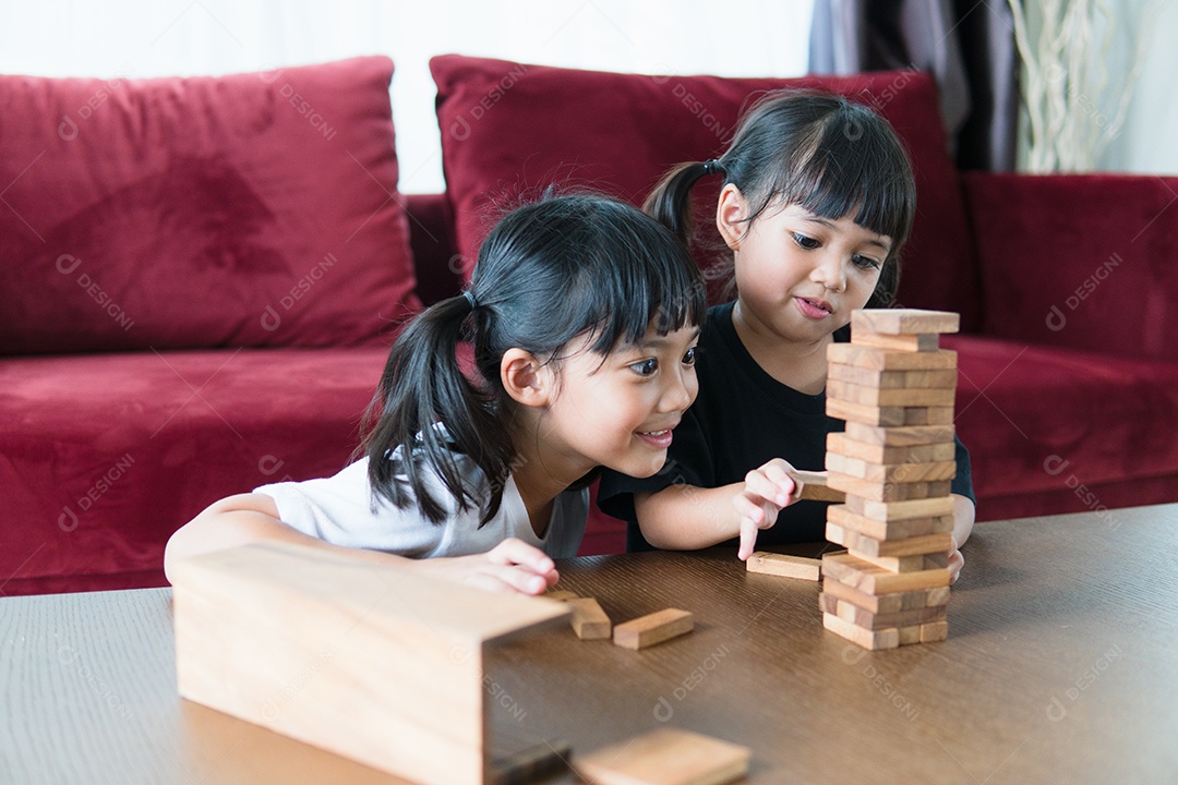 Duas garotas asiáticas jogando pilhas de madeira em casa